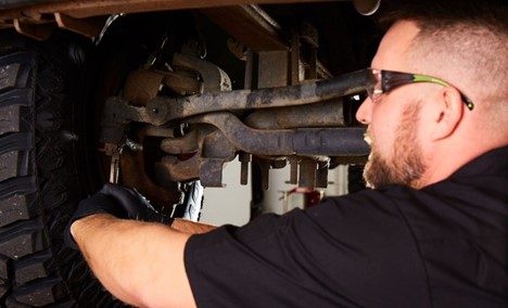 A mechanic inspecting a steering system for damage