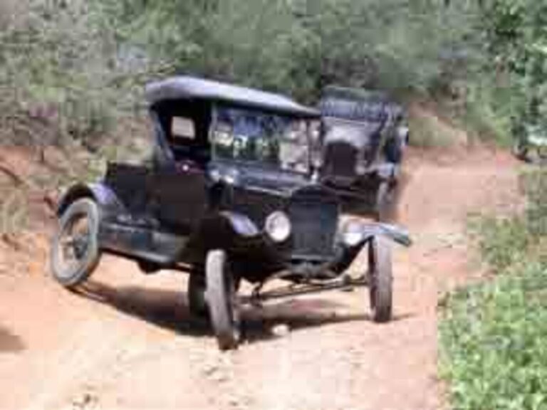 Model T Ford on a dirt road with a middle rut showing how the suspension components work