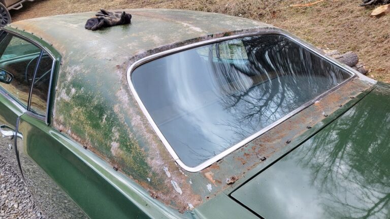 A green Chevy Monte Carlo with the vinyl top removed showing the glue residue