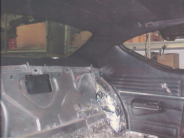 A view of the rear portion of a Chevy Chevelle interior with the car insulation installed on the floor and the side black interior panels in place