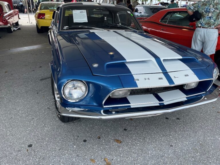 A blue with white stripes Ford Shelby Cobra awaiting sale at a classic car auction for car investor
