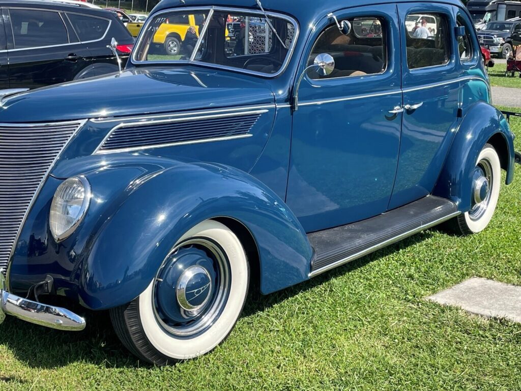 1940 Blue Ford 4 door sedan in a car show field for sale and questions for vintage car buying