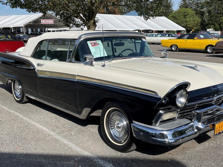 A blue and white For Fairlane in a parking lot before a car auction so buyers can ask questions about vintage car buying