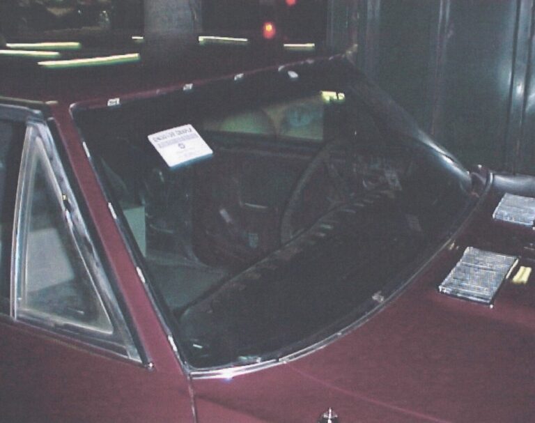 A burgundy 1968 Chevy Chevelle freshly painted and drying using a car restoration guide