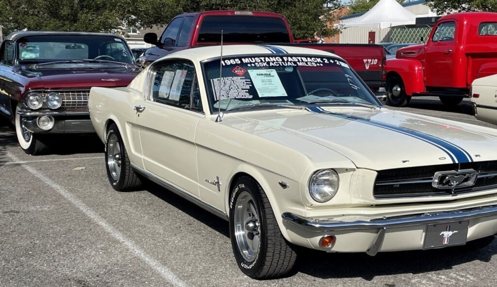 White with blue stripes 1965 Ford Mustang at an auction sale noting common mistakes when selling a classic car