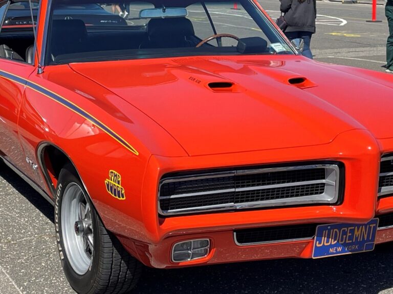 An orange with black/yellow stripes Pontiac GTO Judge with Judgemnt New York license plate showing an example of car paint colors