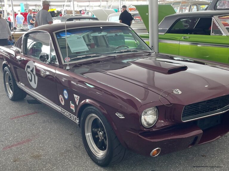 A burgundy Ford Mustang race car with number 51 on the side for sale at an auction for classic car investing