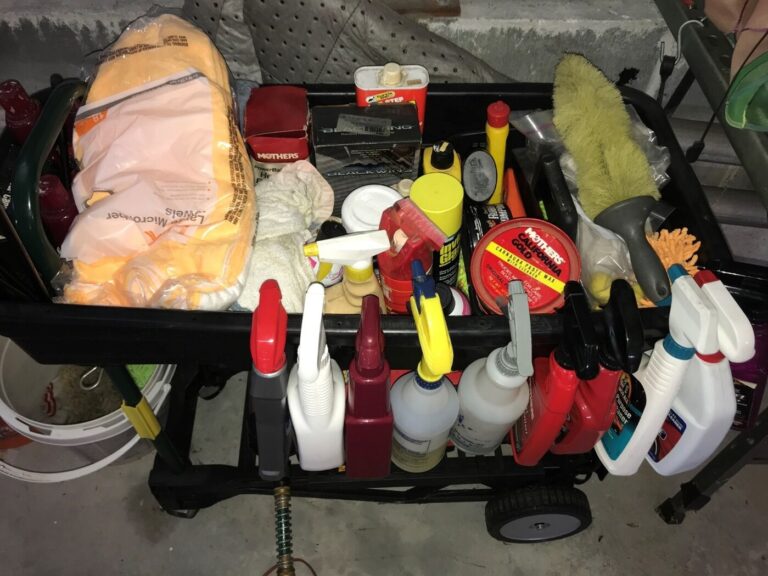 A rollinng black bin containing rags and classic car washing products