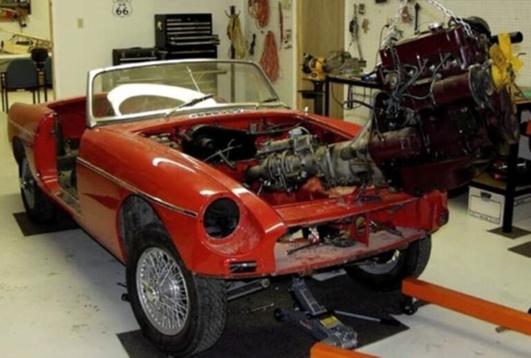Red MG with mechanics remving engine and transmission on hoist requires realistic expectations
