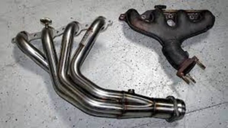 Comparing exhaust system manifolds with a silver header system and an OEM manifold on the right