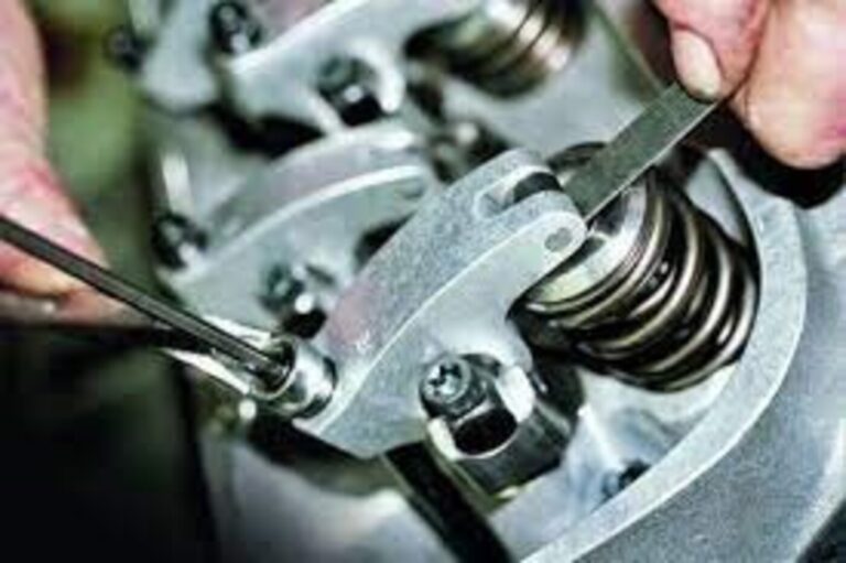 A mechanic working on the valve lash of a V* engine in search of car engine noise