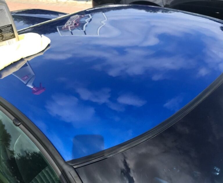 The blue roof of a C5 Corvette after car washing with a spray cleaner and rag on the roof