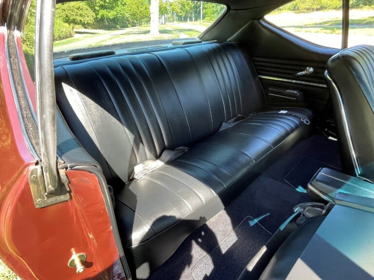 Rear black bench seat inside a Chevy Chevelle showing the restoration work on the car vinyl seats