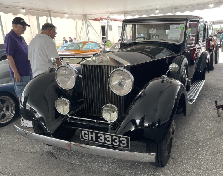 2 classic car experts inspecting a black Rolls Royce at a car auction