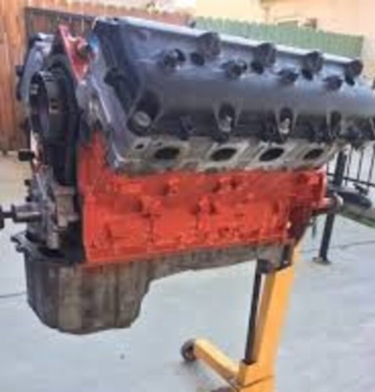 An orange Plymouth Hemi engine with silver heads and black valve covers on a yellow engine stand preparing to avoiding engine rebuilding mistakes