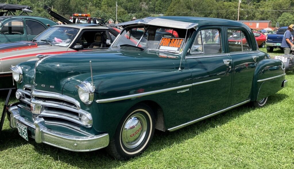 A green 50s Dodge with a for sale sign at a car show prior to the classic car pre-inspections