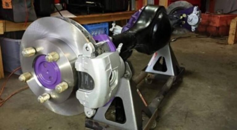 A Ford 9" rear end on floor jacks with aftermarket disc brakes installed with standard vented disc brake rotors