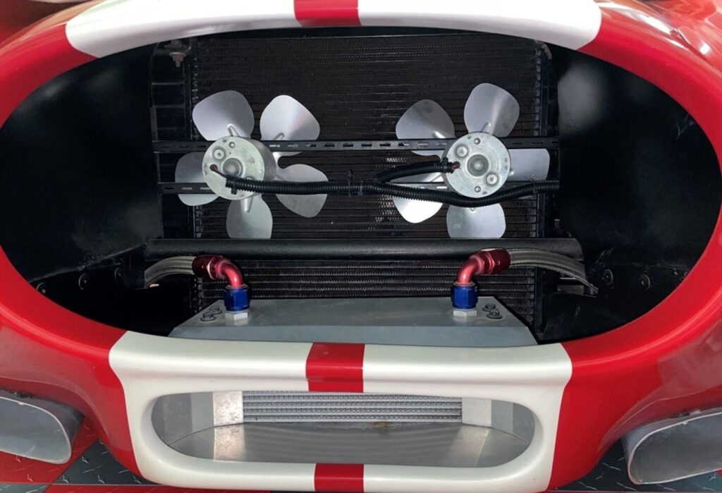 A red with white stripes Cobra with twin electric fans for car engine cooling