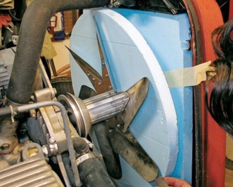 A mechanic working on a radiator and mechanic fan on a hot rod for car engine cooling