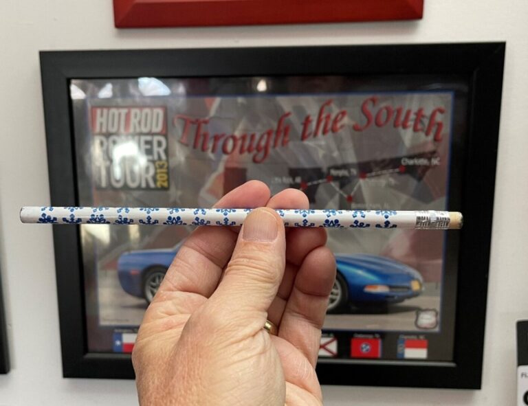A person using a white pencil to simulate the proper car's weight distibution