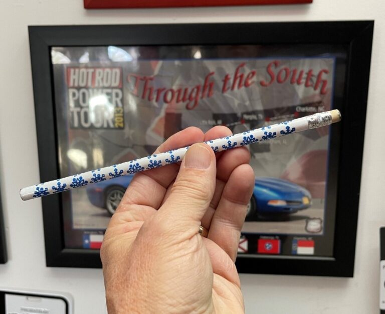 Using a white pencil as an example of the car braking and moving the car's weight distribution to the front and lower.