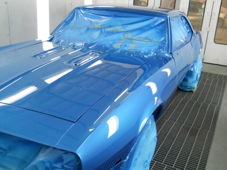 A blue Chevy Camaro recently painted in an autobody paint booth awaiting for inspecting car paint job quality