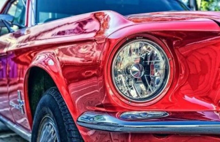 An aftermarket halogen car headlight on a red 68 Ford Mustang