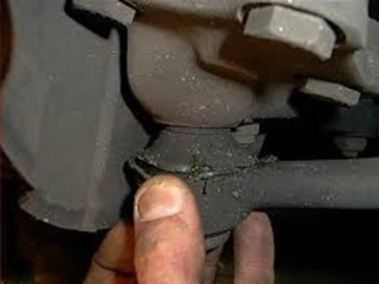 mechanic holding the steering knuckle while working on the car steering alignment