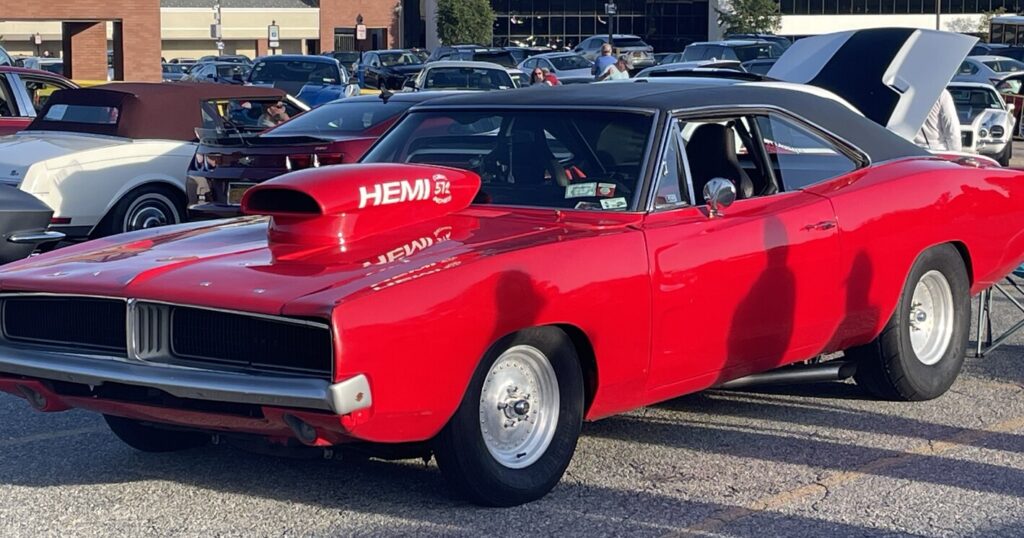 A red with black vinyl top Plymouth Charger with a hood scoop reading HEMI ready to race with a performance torque converter