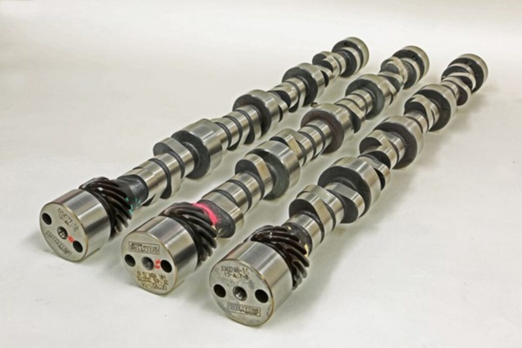 Three different car engine camshafts side by side to compare cam design differences