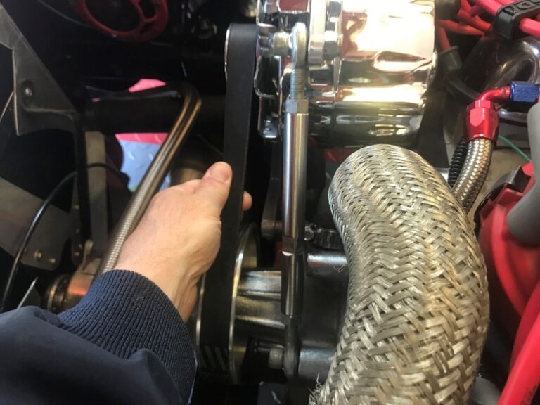 A mechanic inspecting the engine belts as part of preparing your car for the 1st spring drive