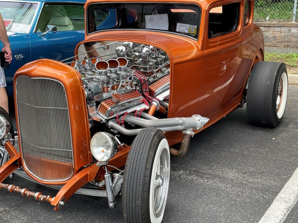 A custom orange 5-window coupe with a Chevy engine putting out 327 CI car engine displacement