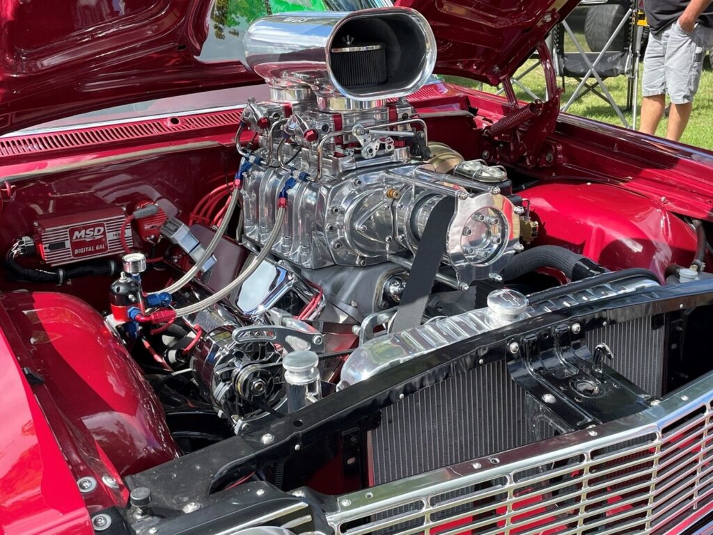 A red Chevy with an all-chrome supercharged car engine