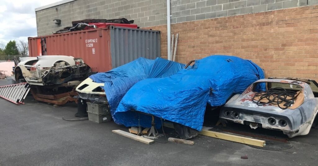 Various Chevy Corvette car bodies sitting in a parking lot unrestored due to problematic restoration contract clauses