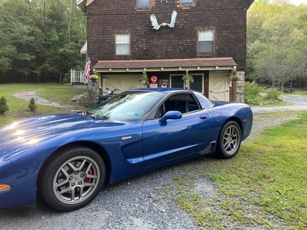 A blue C5 Corvette sitting outside a rural inn near one of the best cities for classic cars