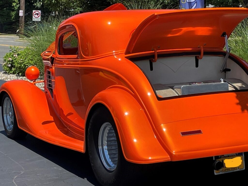 An orange 1934 Chevy 3 window coupe after choosing to swap rear ends with a Ford 9-inch