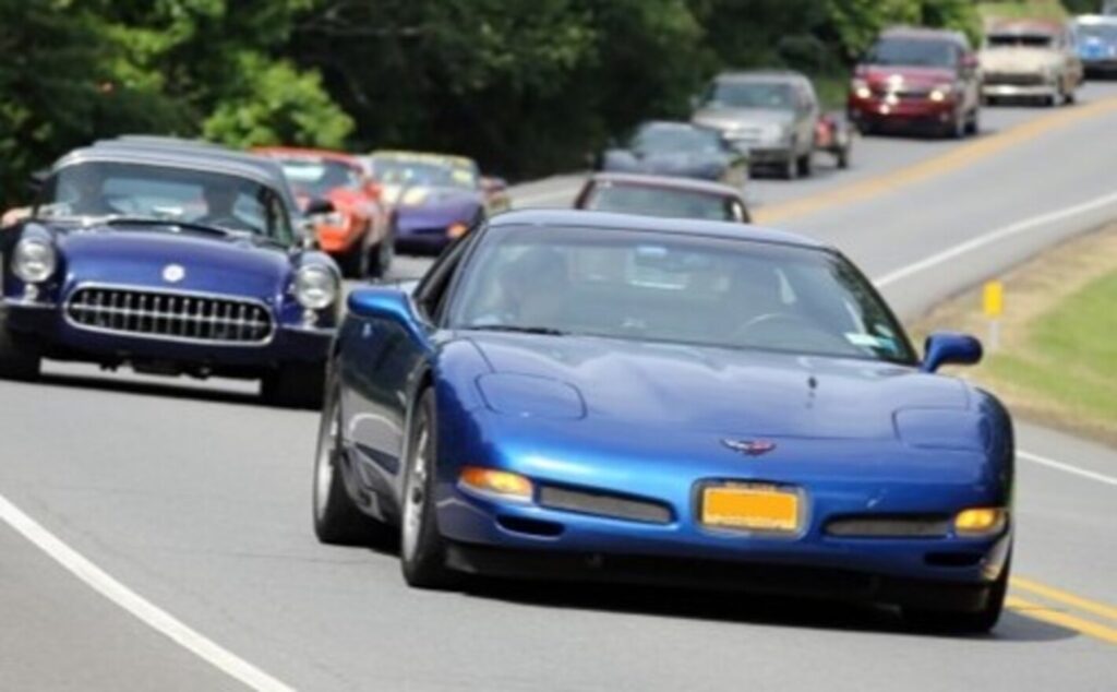 2 blue Corvettes driving on a back road with the second old C1 Corvette with cost-effective upgrades to improve drive quality