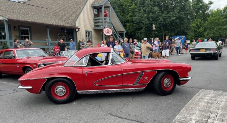 A red C1 Corvette driving thru a parking lot car show with cost-effective upgrades for better drivability