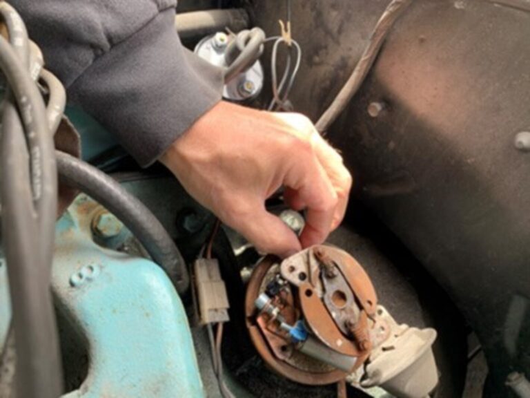 A mechanic check on the internal operation of an engine distributer to avoid car engine problems