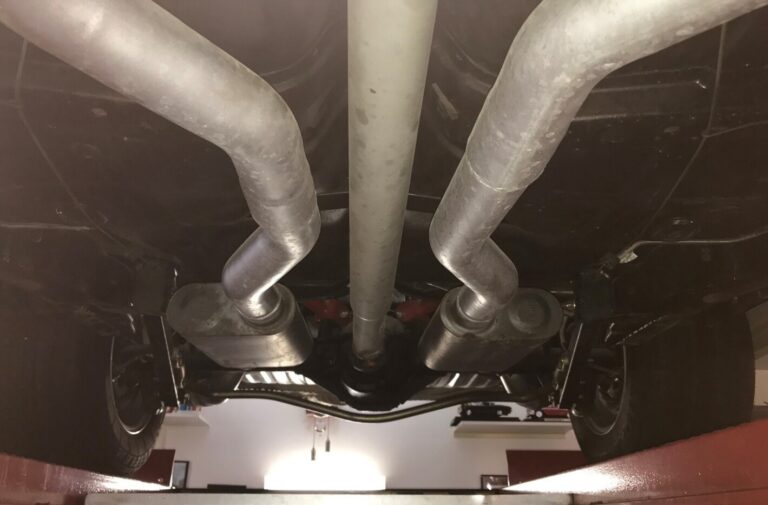 A dual stainless 3" exhaust system and silver drive shafter under a 68 Chevelle