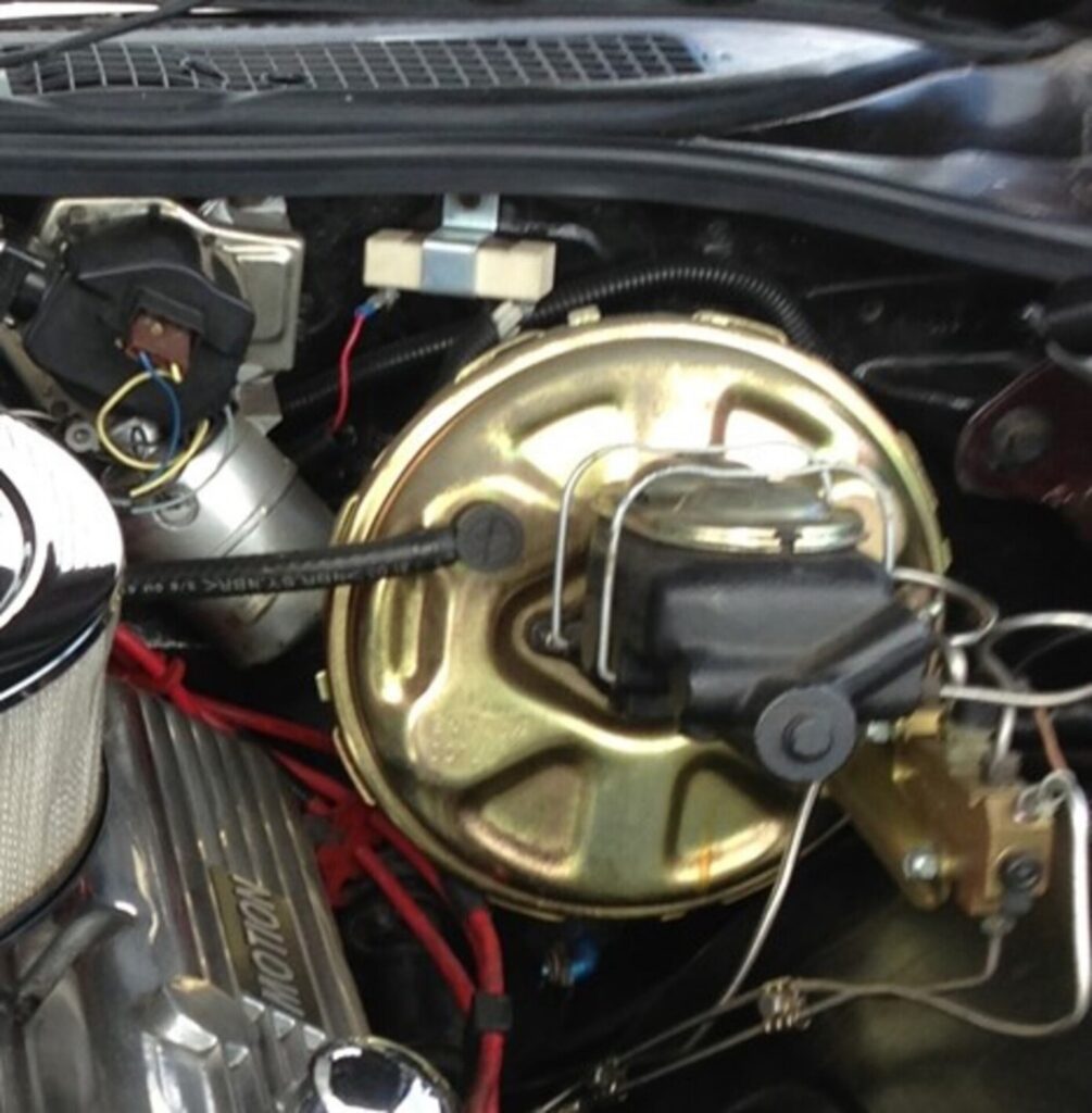 A brake master cylinder with power brake booster in a Chevy in preparation for bleeding air out of the system