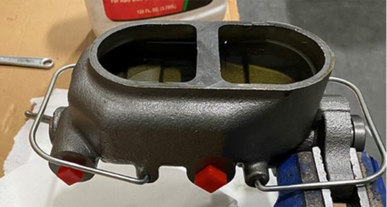 A brake master cylinder filled with fluid in preparation to bleed air from the system