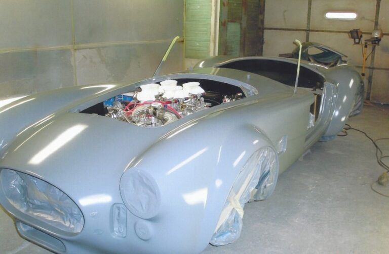 A 65 Cobra replica in primer being prepared for paint a reputable car paint shop