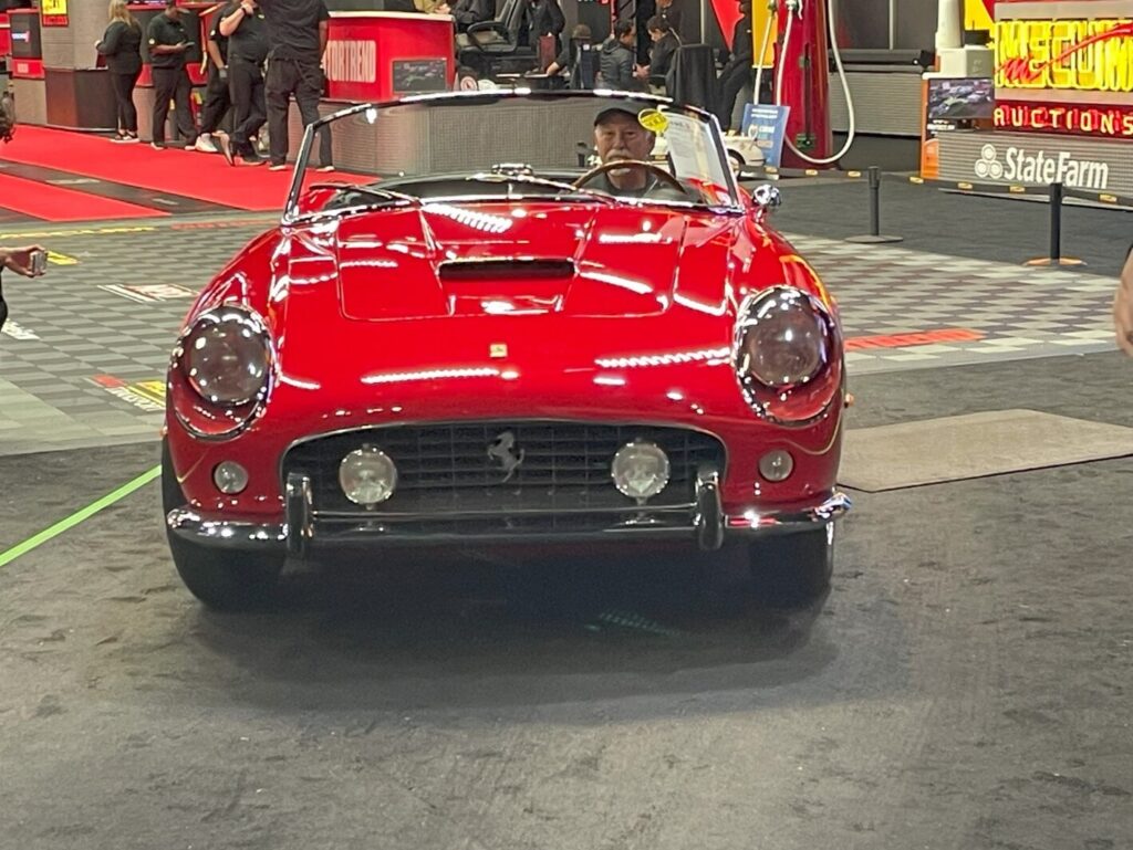 A red classic Ferrari convertible crossing the auction block in search for the perfect vintage car