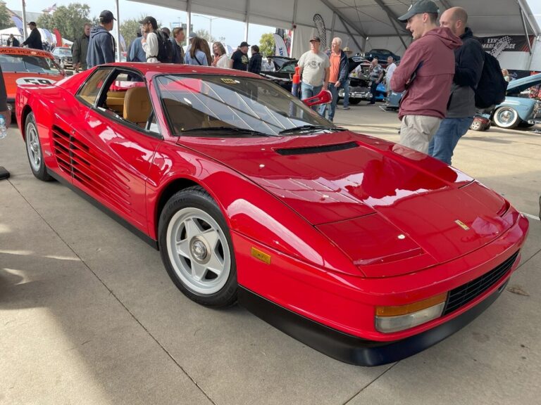 2 men looking at a red Ferrari Testarossa in search of the perfect vintage car