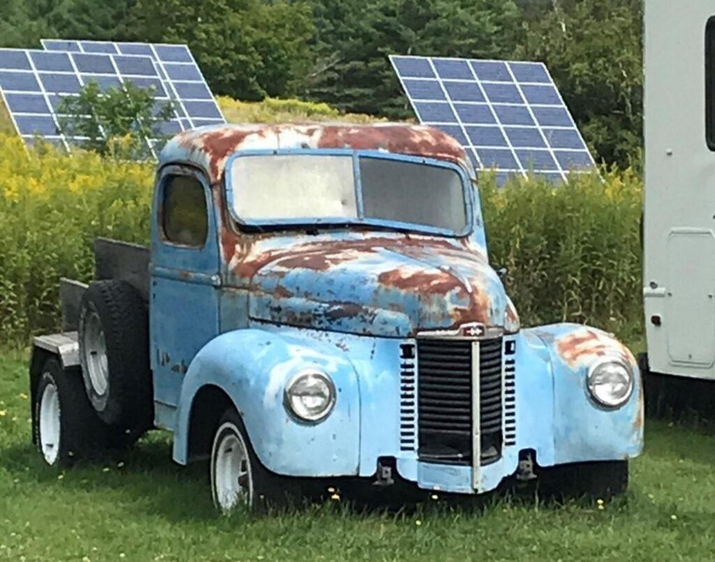 A rusty light blue 50s Internation Harvester truck parked in a field needed car restoration
