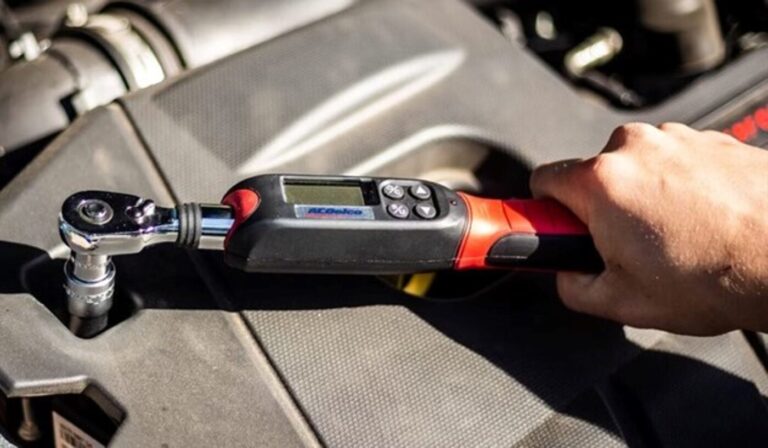 A mechanic using a digital torque wrench car repair tool