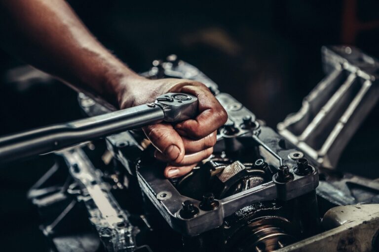 A mechanic with a torque wrench working on a rebuilt engine