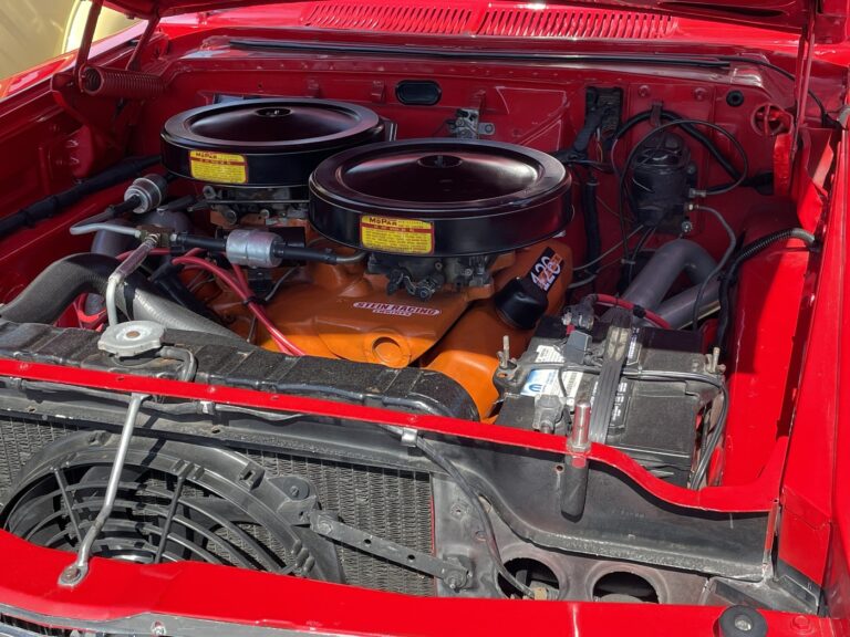 A Dodge 428 remanufactured engine painted orange in a red car