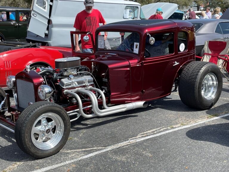 A chrome Chevy stroker engine in a burgundy Hot Rod at a car show